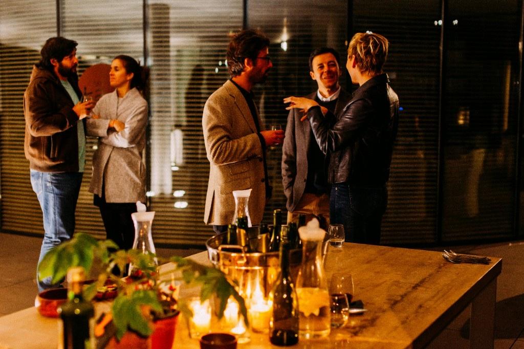 Guests talking over wine at a night gathering