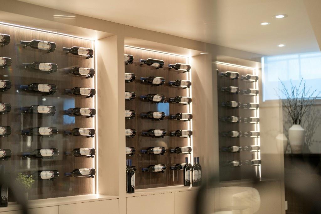 Wine bottles in a lit cellar wall