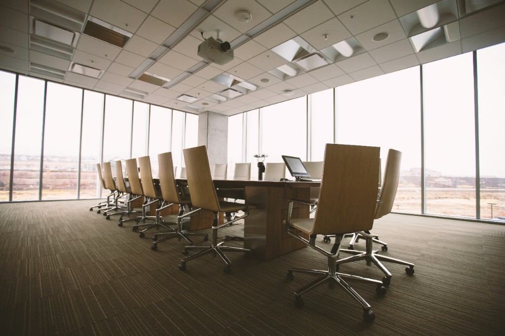 Sunlit conference room with a long table and high-back chairs